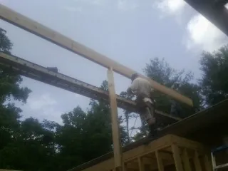 Carpenter setting a ridge beam over a new addition frame — Ice Dam Removal by Roofing Brothers in Cordova
